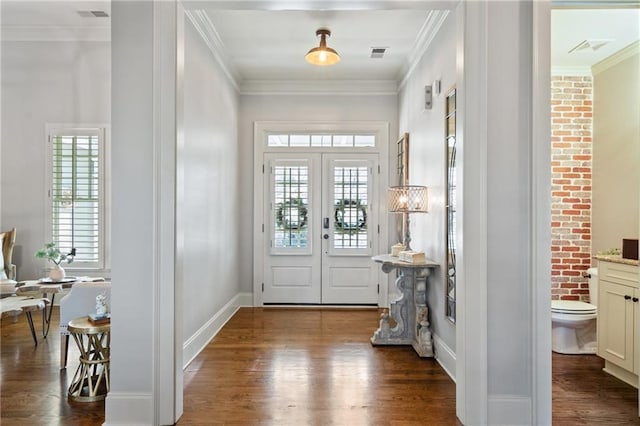 entryway with ornamental molding, dark wood-type flooring, visible vents, and baseboards