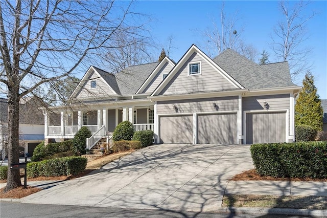 view of front facade with covered porch, an attached garage, a shingled roof, and driveway