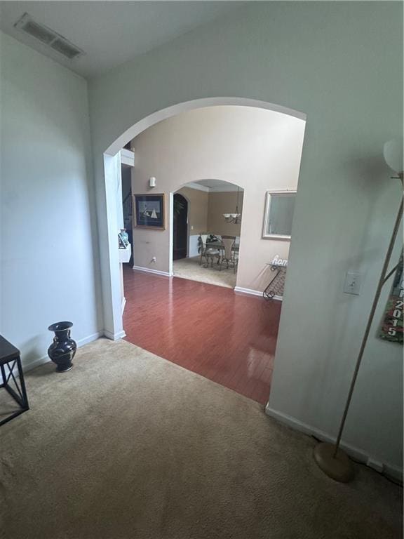 458 Vinings Vintage Cir, Mableton, GA 30126 - empty room featuring arched walkways, carpet, baseboards, and wood finished floors