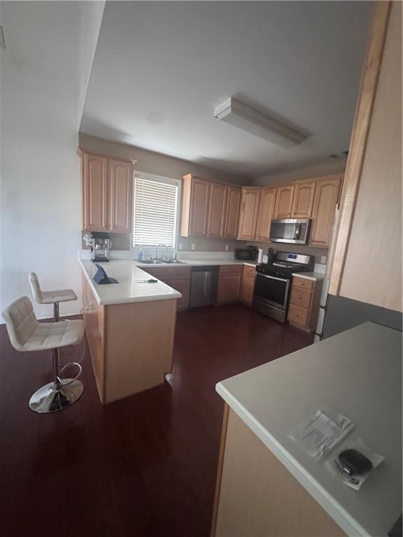 458 Vinings Vintage Cir, Mableton, GA 30126 - kitchen featuring stainless steel appliances, a peninsula, light brown cabinets, a sink, and light countertops