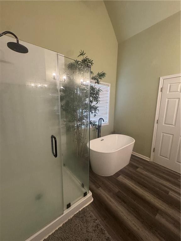 458 Vinings Vintage Cir, Mableton, GA 30126 - bathroom featuring a stall shower, a freestanding bath, wood finished floors, high vaulted ceiling, and baseboards