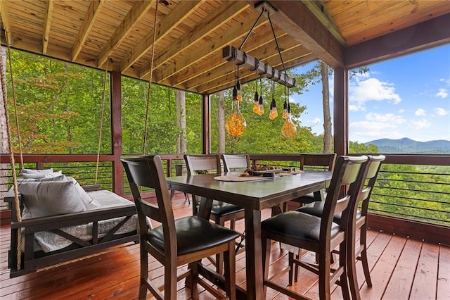 sunroom featuring wood ceiling, a mountain view, and beam ceiling