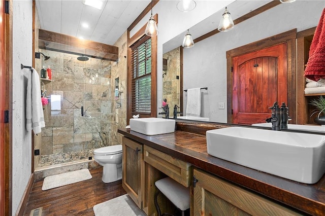 bathroom with wood-type flooring, toilet, a shower with door, and vanity