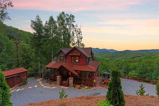 log home with a mountain view, a storage shed, and a porch