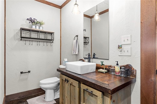 bathroom with tiled shower, vanity, and toilet