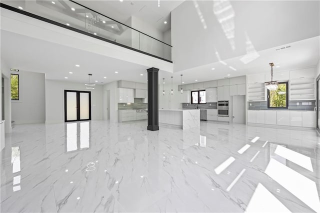 4238 Hamilton Mill Rd, Buford, GA 30519 - unfurnished living room featuring a high ceiling, decorative columns, recessed lighting, and light marble finish floors