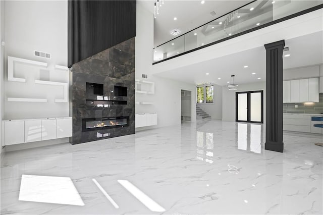 4238 Hamilton Mill Rd, Buford, GA 30519 - unfurnished living room featuring a high ceiling, marble tiled flooring, a fireplace, stairs, and decorative columns