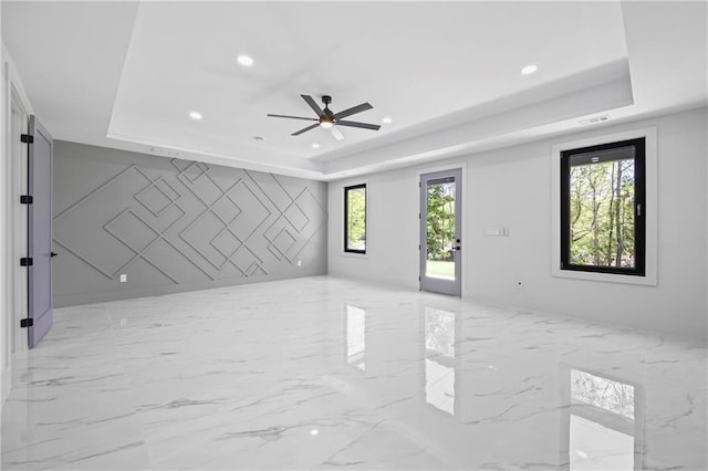 4238 Hamilton Mill Rd, Buford, GA 30519 - spare room featuring a tray ceiling, light marble finish floors, ceiling fan, and recessed lighting