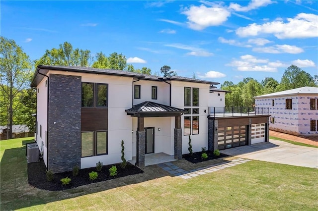 4238 Hamilton Mill Rd, Buford, GA 30519 - contemporary house with stucco siding, concrete driveway, a front yard, a standing seam roof, and metal roof