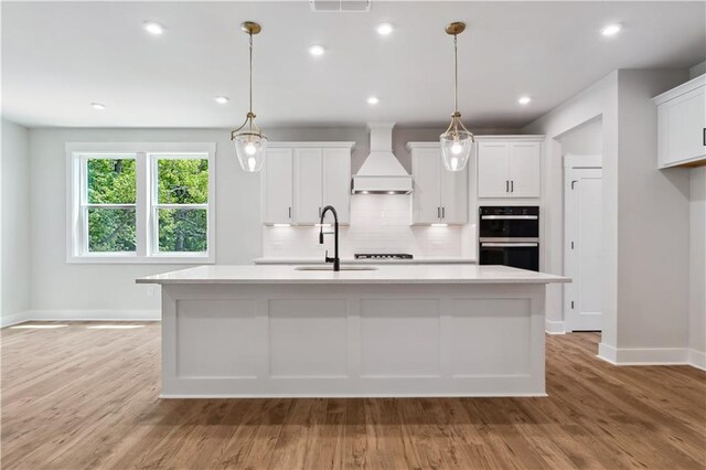 4002 Adler Cir, Buford, GA 30519 - kitchen featuring baseboards, light countertops, dobule oven black, and custom exhaust hood