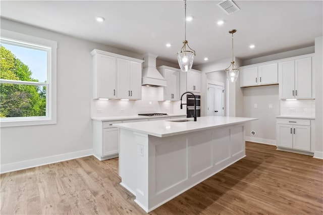 4002 Adler Cir, Buford, GA 30519 - kitchen with a sink, decorative backsplash, a kitchen island with sink, premium range hood, and visible vents