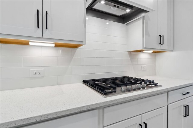 4002 Adler Cir, Buford, GA 30519 - kitchen with stainless steel gas stovetop, decorative backsplash, white cabinets, and custom range hood