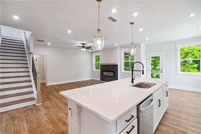 4002 Adler Cir, Buford, GA 30519 - kitchen with dishwasher, visible vents, a sink, and a lit fireplace