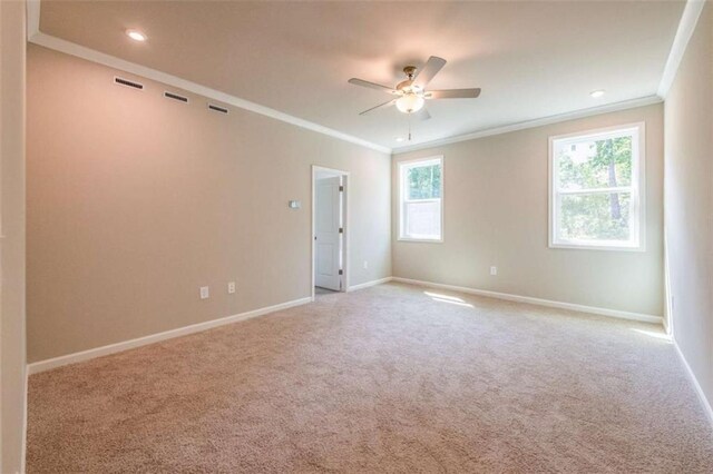 carpeted spare room featuring ceiling fan and crown molding