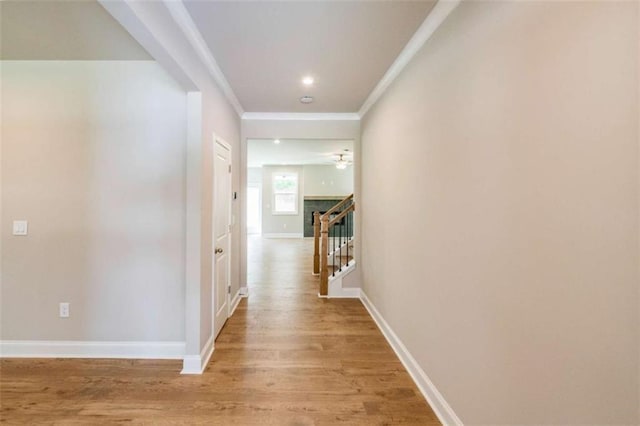 corridor featuring light wood-type flooring and crown molding