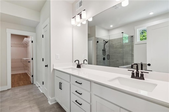 4002 Adler Cir, Buford, GA 30519 - bathroom featuring a walk in closet, a shower stall, visible vents, and a sink