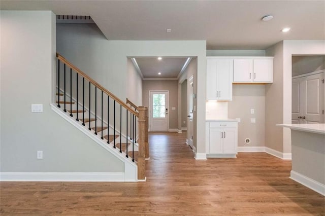 kitchen featuring crown molding, light hardwood / wood-style flooring, and white cabinets