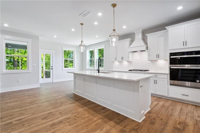 4002 Adler Cir, Buford, GA 30519 - kitchen with light countertops, a sink, premium range hood, black stovetop, and double oven
