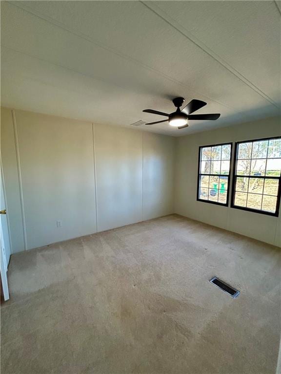 unfurnished room featuring light carpet and ceiling fan