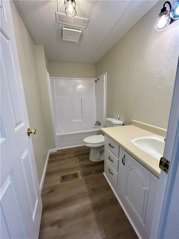 bathroom featuring visible vents, toilet, wood finished floors,  shower combination, and vanity