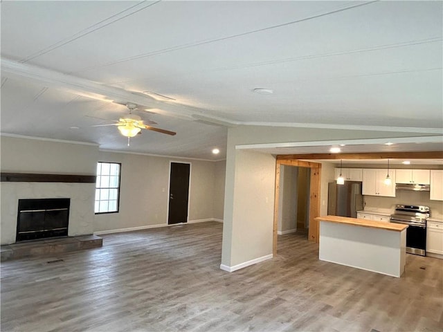 unfurnished living room with a fireplace, lofted ceiling, ornamental molding, ceiling fan, and light hardwood / wood-style floors