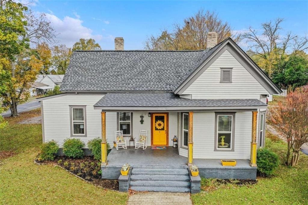 view of front of property featuring covered porch and a front yard