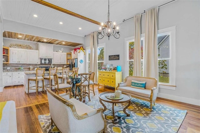 living room featuring light wood-type flooring, an inviting chandelier, and wood ceiling