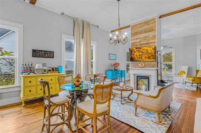 dining area with light wood-type flooring and an inviting chandelier