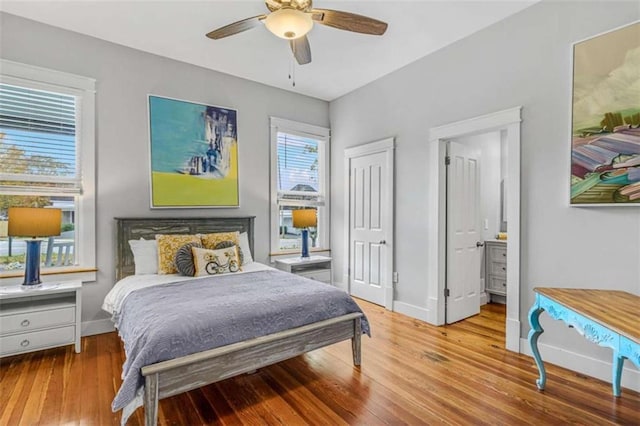 bedroom with ceiling fan, ensuite bathroom, and light wood-type flooring