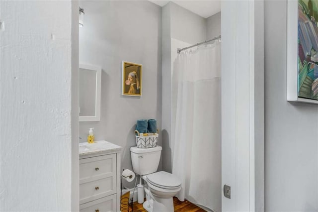 bathroom featuring vanity, wood-type flooring, and toilet