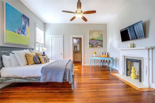 bedroom with hardwood / wood-style floors, ceiling fan, and ensuite bath