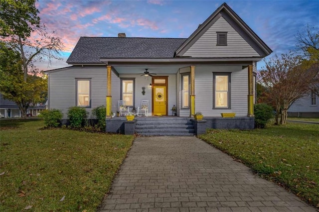 view of front of property featuring a lawn, ceiling fan, and a porch