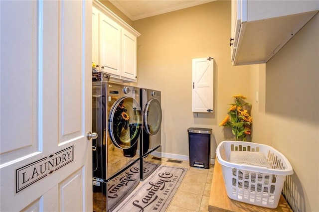 washroom with washing machine and dryer, crown molding, light tile patterned floors, and cabinets