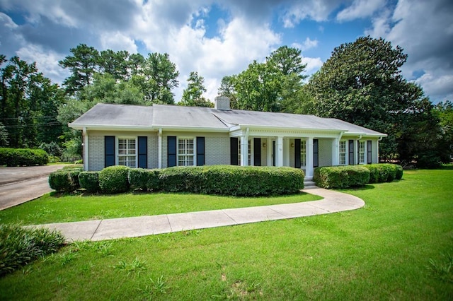 ranch-style house with a front yard, brick siding, and a chimney