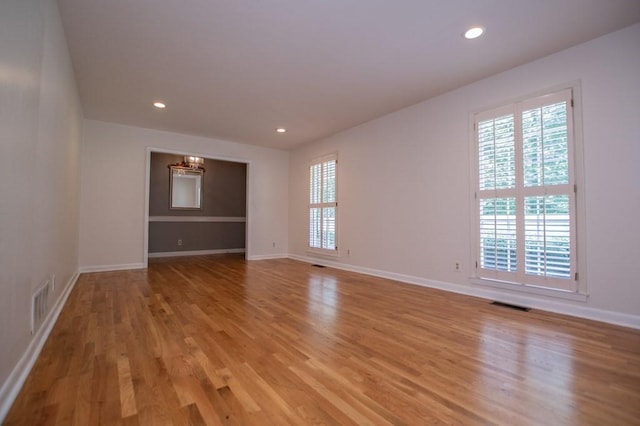 spare room featuring plenty of natural light, light wood-style floors, and visible vents