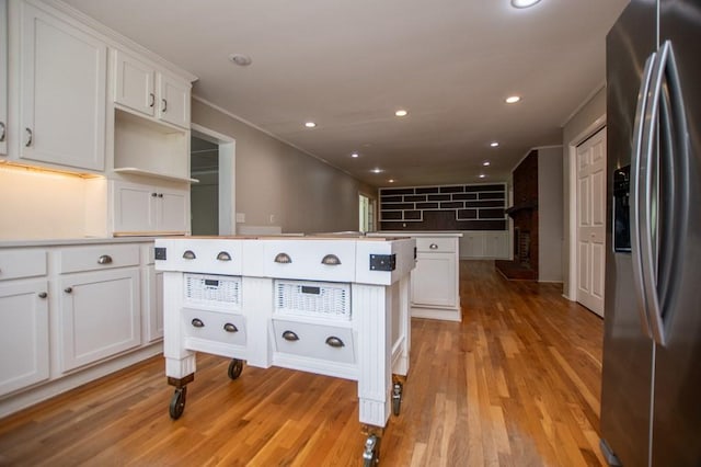 kitchen with recessed lighting, white cabinetry, light wood-type flooring, and stainless steel refrigerator with ice dispenser