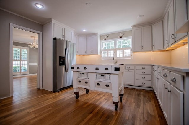 kitchen featuring light countertops, plenty of natural light, stainless steel fridge with ice dispenser, and dark wood-type flooring