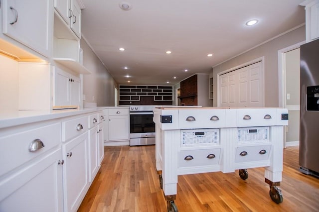 kitchen with recessed lighting, light countertops, light wood-style floors, appliances with stainless steel finishes, and white cabinetry