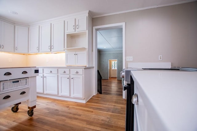 kitchen featuring white cabinetry, light countertops, light wood finished floors, and ornamental molding