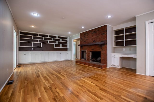 unfurnished living room featuring visible vents, ornamental molding, recessed lighting, a fireplace, and light wood finished floors