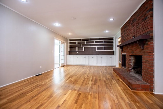 unfurnished living room with recessed lighting, a fireplace, crown molding, and light wood finished floors