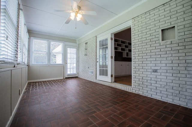 unfurnished sunroom featuring a ceiling fan