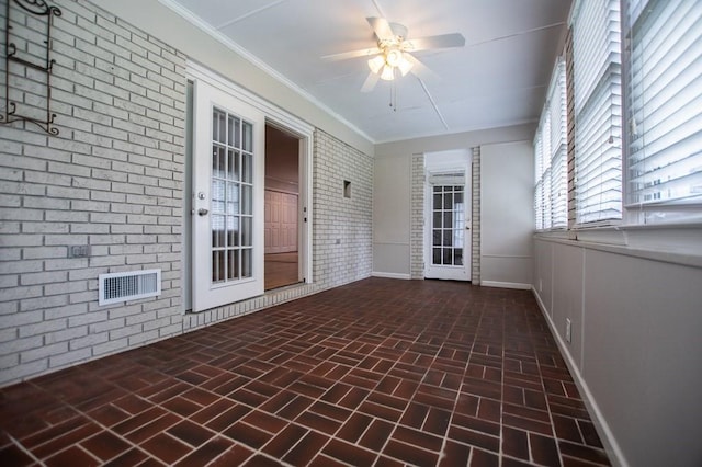 unfurnished sunroom featuring visible vents and ceiling fan