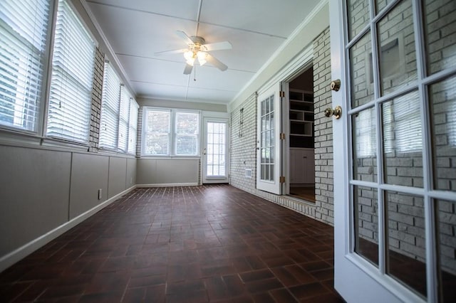 unfurnished sunroom with ceiling fan