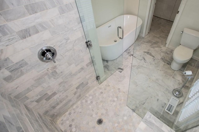 bathroom featuring a soaking tub, visible vents, toilet, and walk in shower