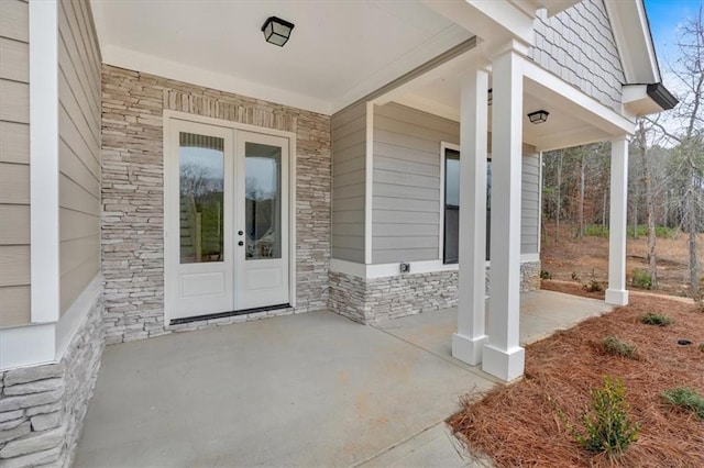 view of exterior entry with stone siding and french doors