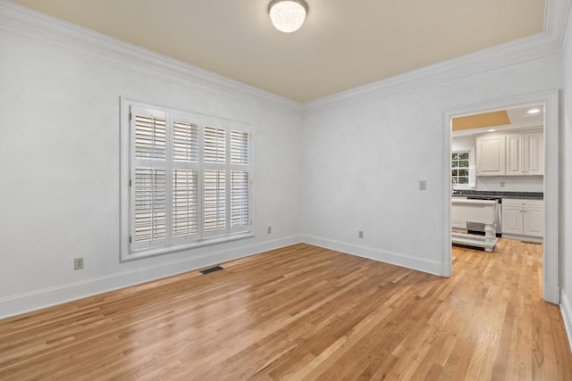 unfurnished room featuring light hardwood / wood-style flooring and crown molding