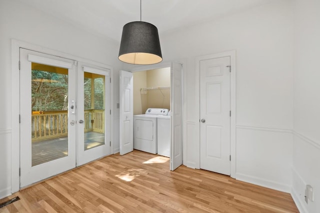 interior space with french doors, washer / dryer, and light hardwood / wood-style flooring