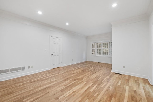 spare room with light wood-type flooring and crown molding