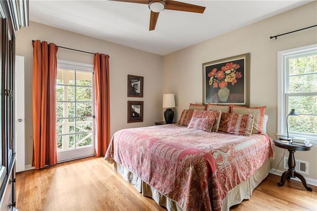 bedroom with a ceiling fan, baseboards, visible vents, and wood finished floors